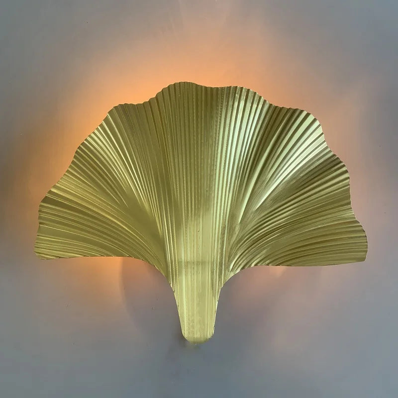 Decorative wall light shaped like a leaf on a plain background