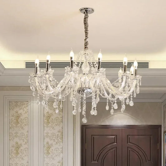 A close-up view of the central column and arms of a gold crystal chandelier, showcasing the detailed metalwork and crystal embellishments.
