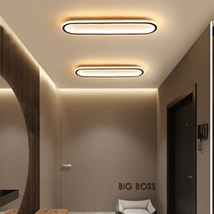 A hallway with two modern oval flush mount ceiling lights installed on the ceiling.
