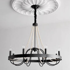 Black chandelier with pearl-like beads against a white ceiling