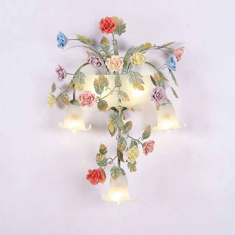 Close-up of the gold floral wall sconce, showing the intricate ceramic rose buds and leafy details.