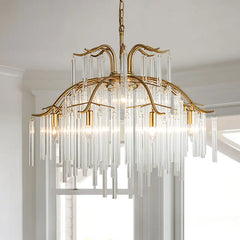 A gold-finished tiered chandelier with numerous clear glass rods cascading downwards, suspended by a chain from a ceiling.