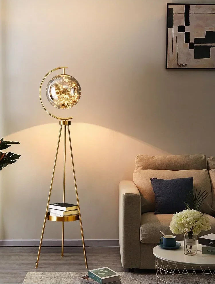 Gold floor lamp in a living room setting with a sofa and coffee table.