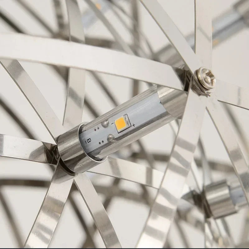 Close-up of a metallic mechanical component with a clear tube and yellow light bulb inside.