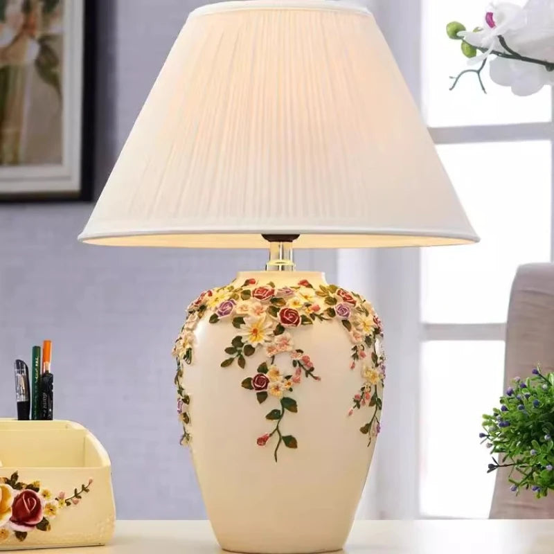 Decorative table lamp with floral design on a blurred indoor background