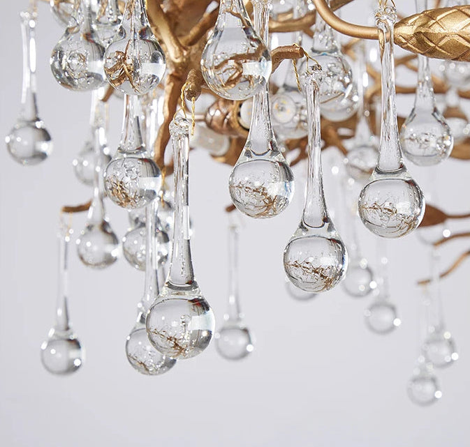 Close-up of a crystal chandelier with clear glass droplets on a light gray background.