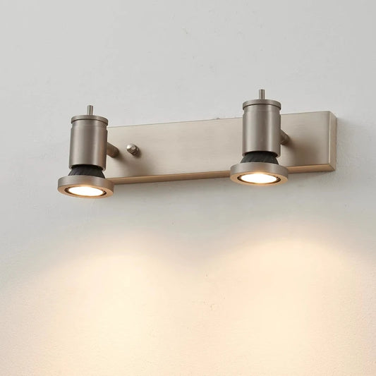Close-up of a two-head adjustable LED wall sconce with a silver finish mounted on a brushed metal bar.