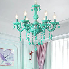 A cyan crystal chandelier installed in a room with light blue walls and pastel curtains, casting a soft glow.