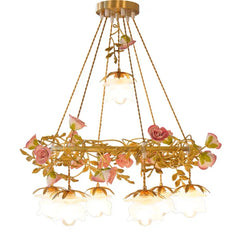 Frontal view of a gold pendant light featuring a ring structure with intertwined ceramic pink roses and green leaves, suspended by golden cords.