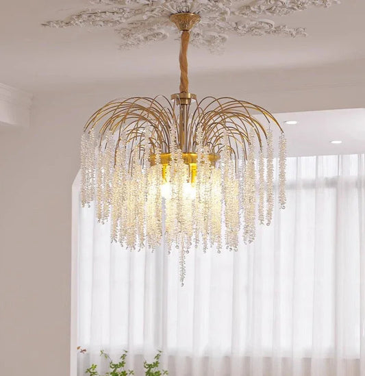 Close-up view of a gold frame chandelier adorned with numerous clear crystal droplets.
