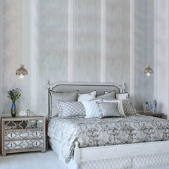 A bedroom with two wood carved floral pendant lights hanging on either side of the bed.