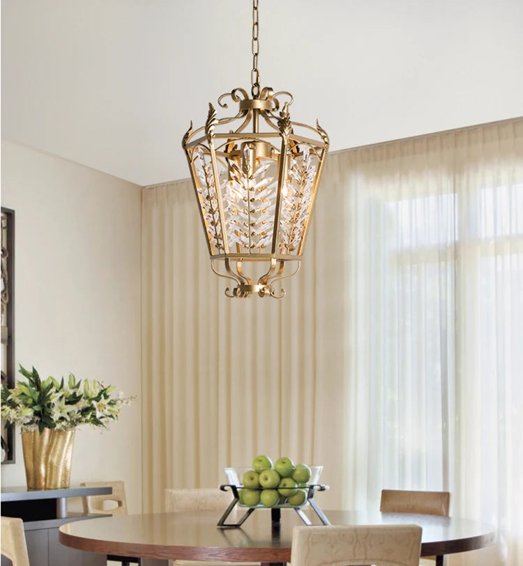 Decorative pendant light hanging above a dining table with green apples and flowers.