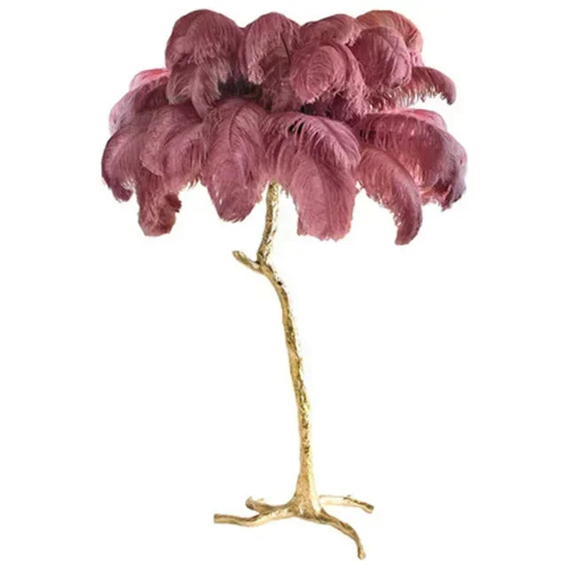 Decorative lamp with pink feathers and gold base on a white background