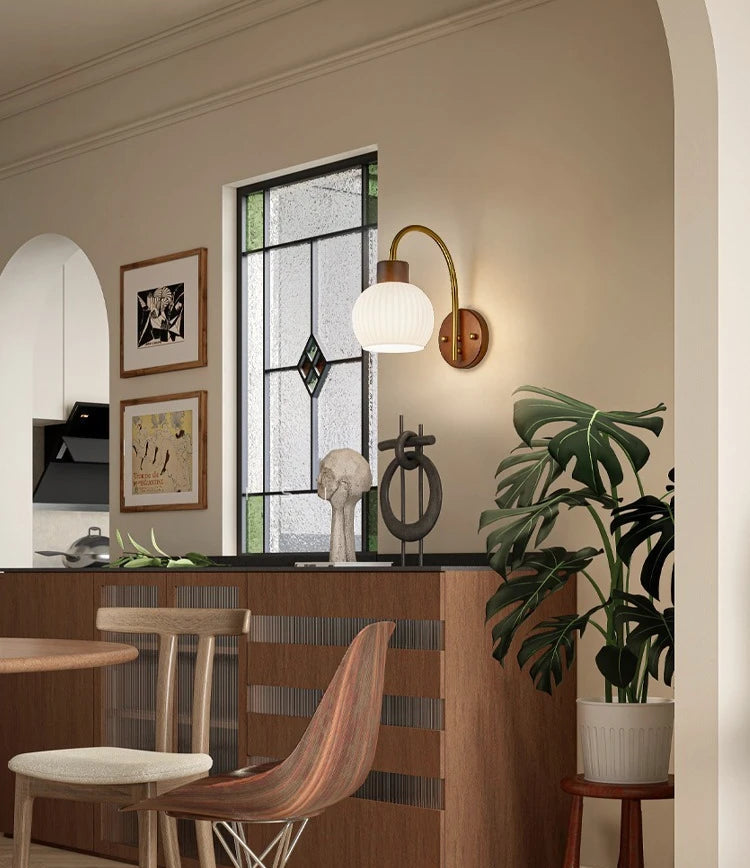 Dining room with wooden furniture, wall sconces, and a window with decorative grille.