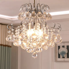 A clear crystal chandelier with a polished chrome frame, illuminated and hanging in a room setting.