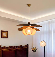 Ceiling fan with light fixture in a room with a bed and window.