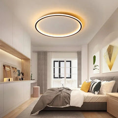 A bright bedroom featuring a modern black circular flush mount ceiling light.