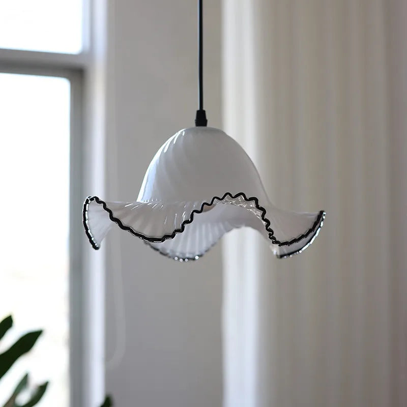 White pendant light with black rim against a neutral background