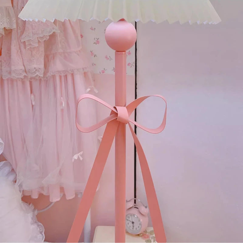 Pink floor lamp with a bow in a room setting