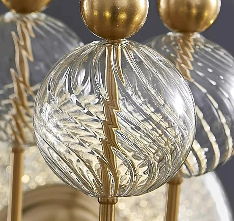Decorative light fixture with gold and clear glass elements on a blurred background