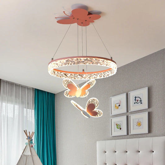 A pink crystal ring pendant light with butterfly accents hanging in a child's bedroom with a teepee and framed art.