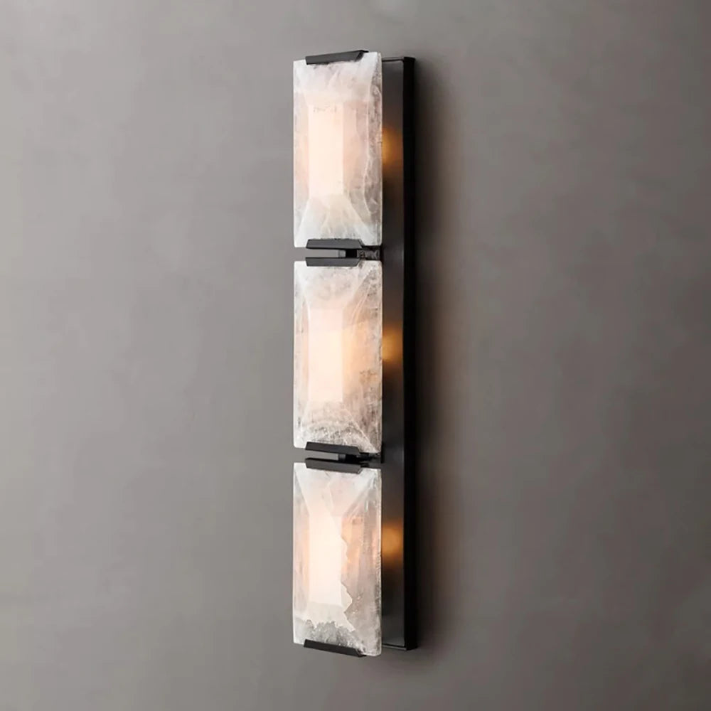 Vertical wall sconce with marble-like design on a gray wall