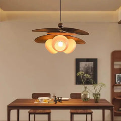 Dining room with a modern pendant light fixture above a wooden table.