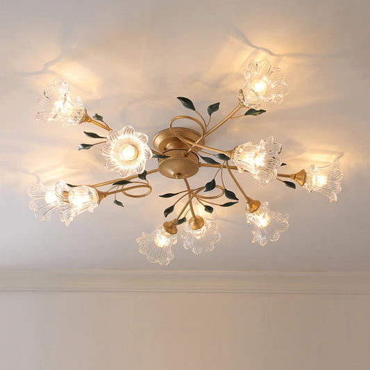 Gold floral semi-flush ceiling light with clear glass shades illuminated against a white ceiling.