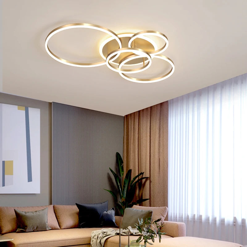 Gold interlocking ring flush mount ceiling light in a modern living room setting.