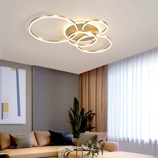 Gold interlocking ring flush mount ceiling light in a modern living room setting.