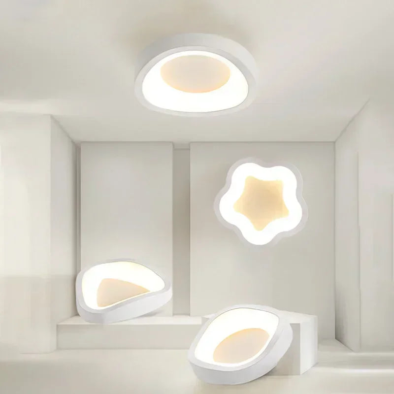 White wavy-shaped ceiling light and other modern geometric lights displayed in a white showroom