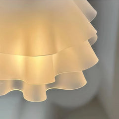 Detailed view of the layered white fabric shades of the chandelier, showing light diffusion.