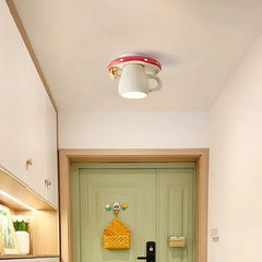 A red and white mushroom-shaped ceiling light with a squirrel accent mounted on a white ceiling above a light green door.