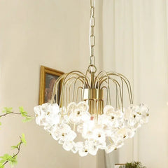 Side view of a gold-tone pendant light adorned with clear glass flowers.