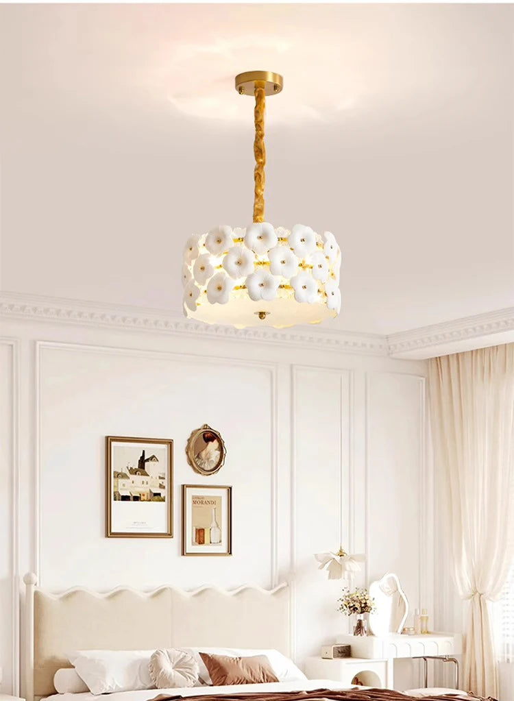 Modern chandelier hanging in a bedroom with white walls and decor.