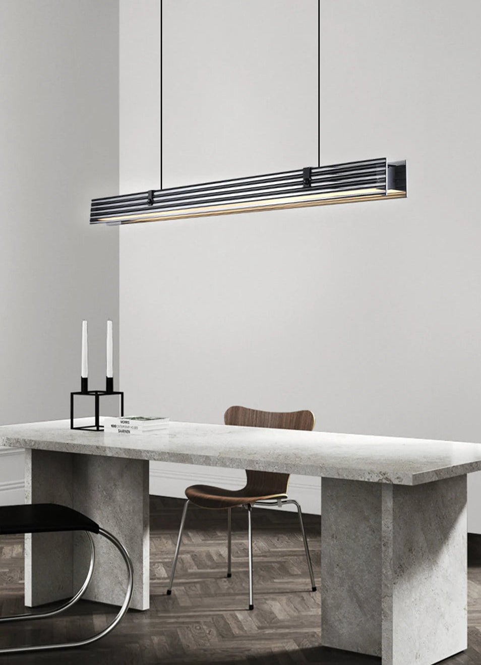 Modern dining area with a concrete table, chairs, and a pendant light.