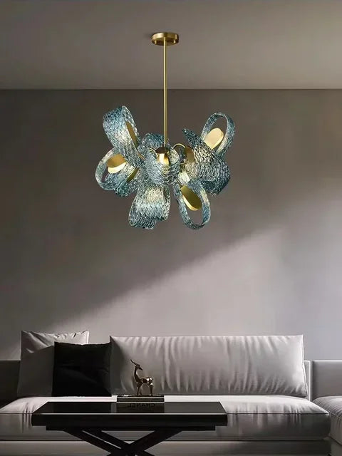 Modern chandelier hanging above a living room with a sofa and coffee table.