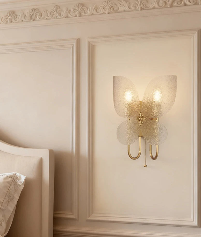 Decorative wall sconce on a cream-colored wall with ornate detailing.