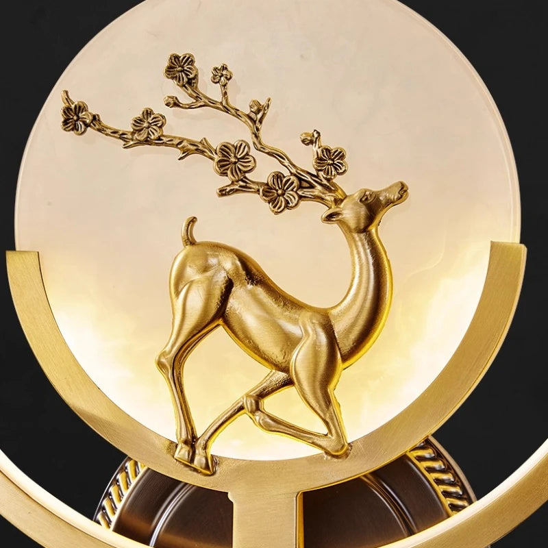 Decorative item with a gold deer and floral branch design on a black background.