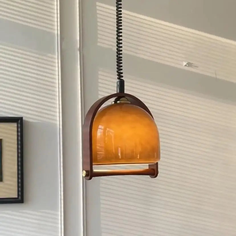 Close-up of the amber glass dome and wood frame on the pendant light.