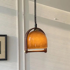 Close-up of the amber glass dome and wood frame on the pendant light.