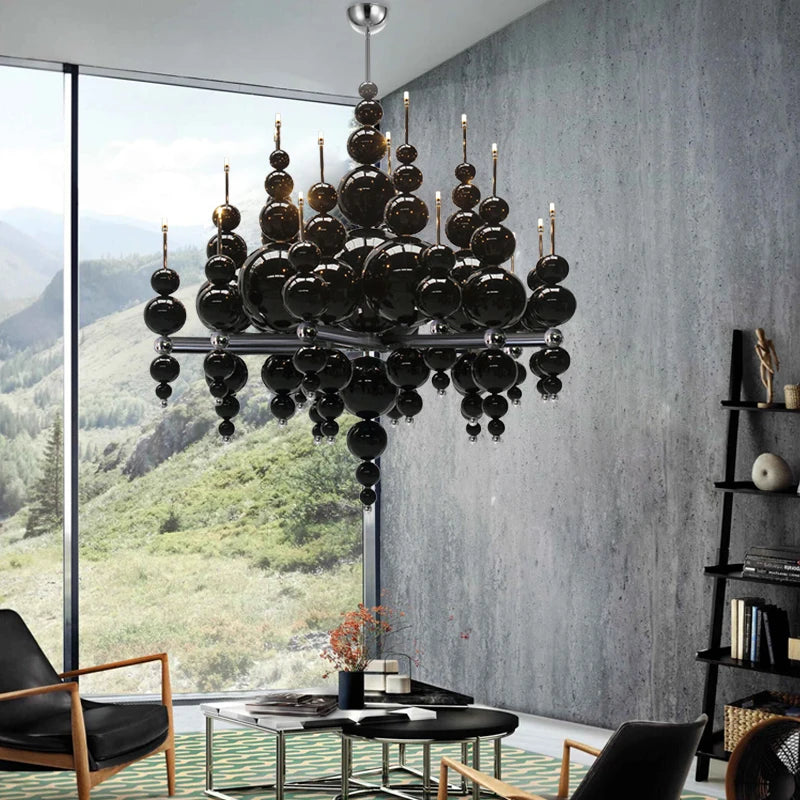 Black globe cluster pendant light with a modern, cascading design in a room with large windows.