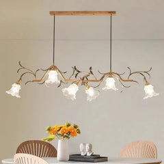 Close-up view of the gold floral branch pendant light, highlighting the intricate details of the metalwork and glass shades.