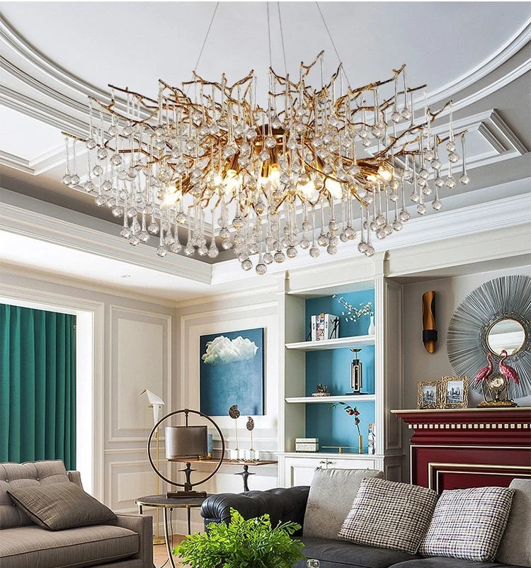 Luxurious living room with a large chandelier, gray sofa, and decorative elements.