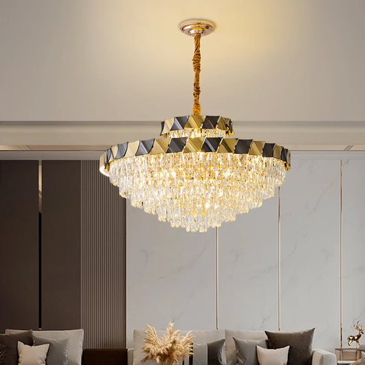 Gold tiered crystal chandelier with cascading crystals hanging from a ceiling in a modern living room.