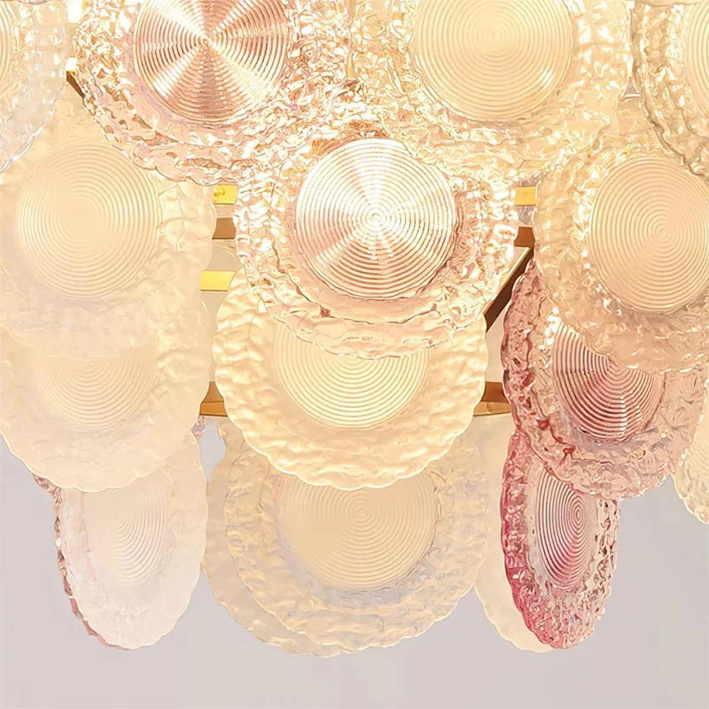 Close-up of a decorative chandelier with circular designs on a light gray background