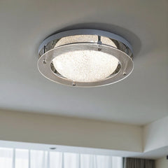 Close-up view of a chrome flush mount ceiling light with a textured frosted glass diffuser.