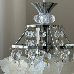 Detailed view of the top section of a chrome pendant light, showing crystal strands and faceted accents.