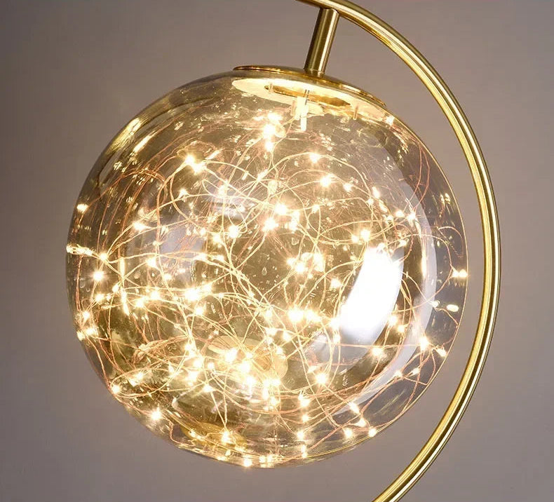 Decorative light fixture with gold frame and illuminated interior on a gray background