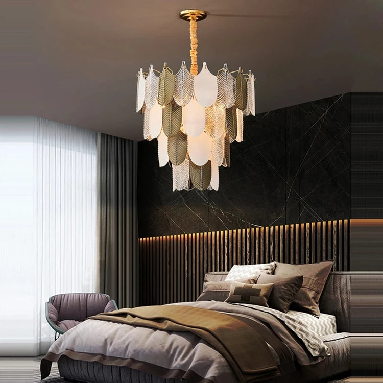 Modern bedroom with a chandelier, bed, and armchair.